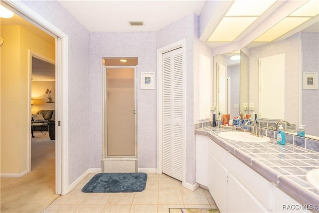 bathroom with an enclosed shower, vanity, and tile patterned flooring