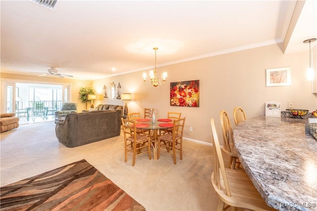 carpeted dining space featuring ornamental molding and ceiling fan with notable chandelier