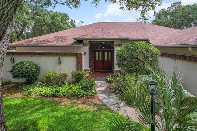 330 E Ireland Ct, Hernando, FL 34442 - view of front facade with a shingled roof, french doors, and stucco siding