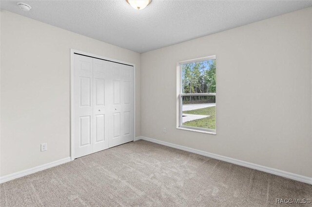6613 N Bedstrow Blvd, Dunnellon, FL 34434 - unfurnished bedroom with carpet flooring, a closet, and a textured ceiling