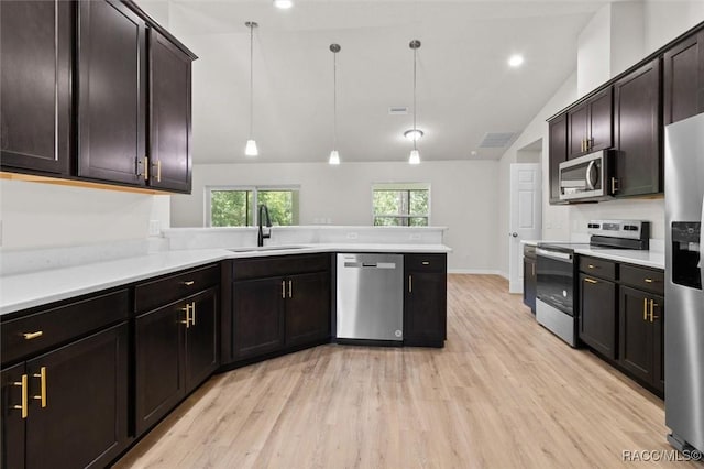 6613 N Bedstrow Blvd, Dunnellon, FL 34434 - kitchen featuring appliances with stainless steel finishes, lofted ceiling, light wood-style flooring, a peninsula, and light countertops