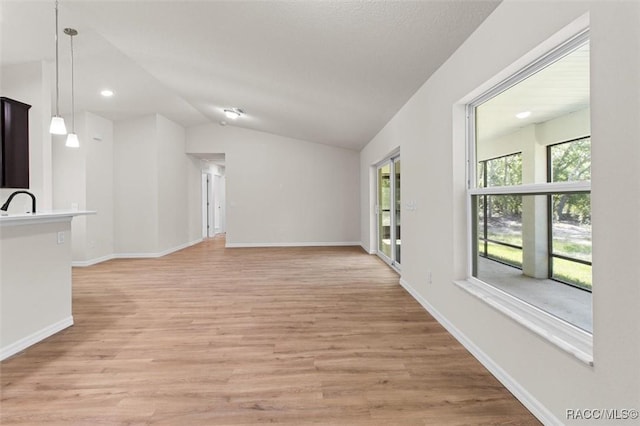6613 N Bedstrow Blvd, Dunnellon, FL 34434 - unfurnished living room with light wood-style floors, vaulted ceiling, and recessed lighting