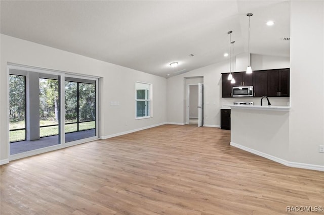 6613 N Bedstrow Blvd, Dunnellon, FL 34434 - unfurnished living room featuring lofted ceiling, light wood-style floors, and recessed lighting