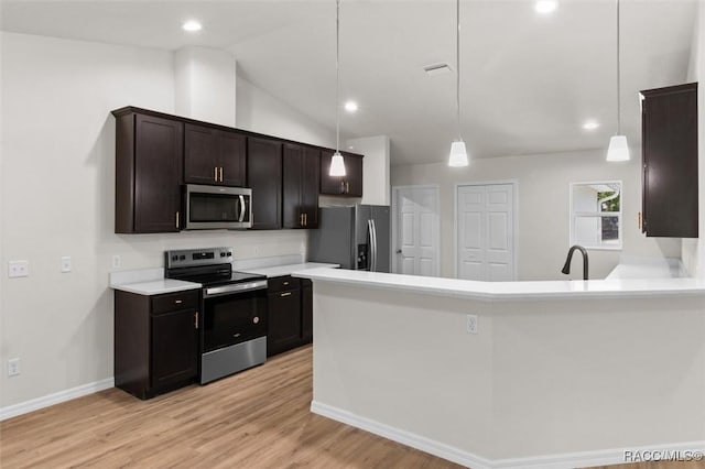 6613 N Bedstrow Blvd, Dunnellon, FL 34434 - kitchen with appliances with stainless steel finishes, light wood finished floors, light countertops, hanging light fixtures, and lofted ceiling