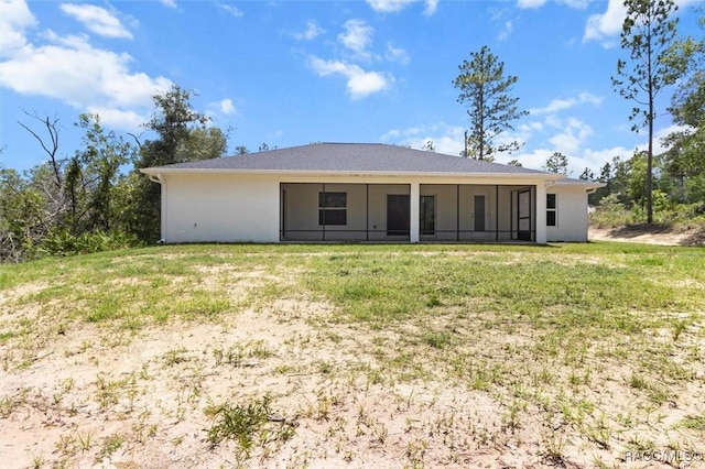 6613 N Bedstrow Blvd, Dunnellon, FL 34434 - rear view of house with a lawn, a sunroom, and stucco siding
