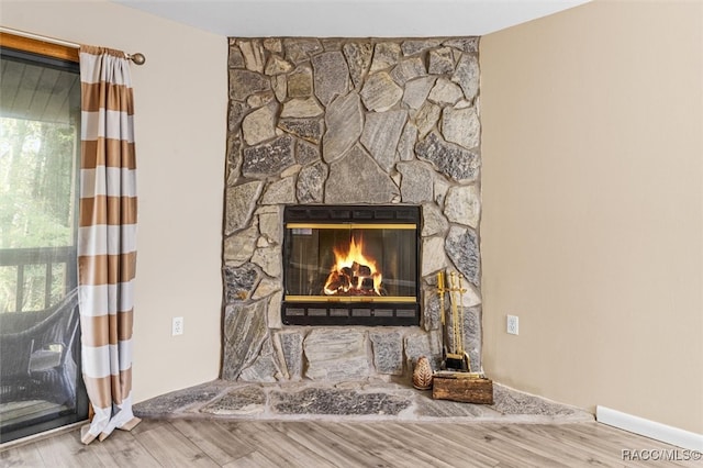 details featuring hardwood / wood-style floors and a stone fireplace