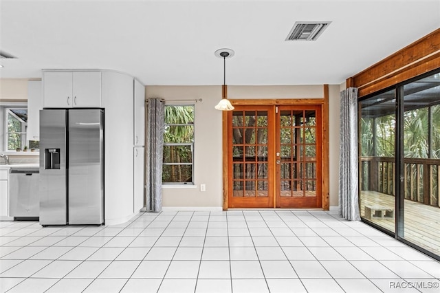 kitchen with french doors, a wealth of natural light, stainless steel appliances, pendant lighting, and white cabinets