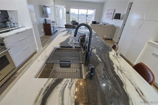 interior details featuring white cabinetry and light wood-type flooring