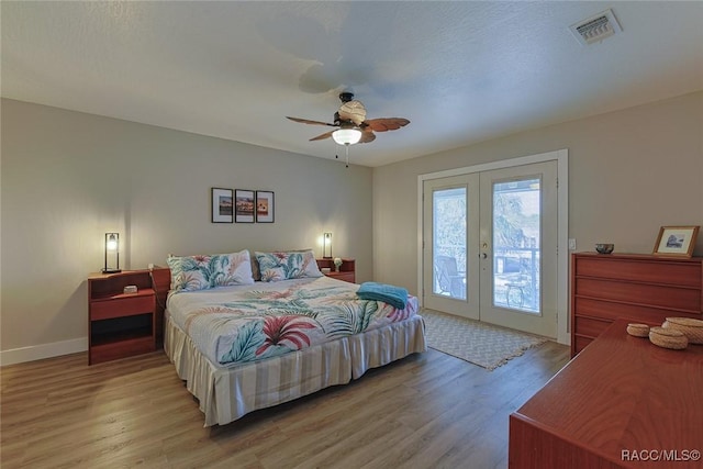 bedroom featuring ceiling fan, access to exterior, light hardwood / wood-style floors, and french doors