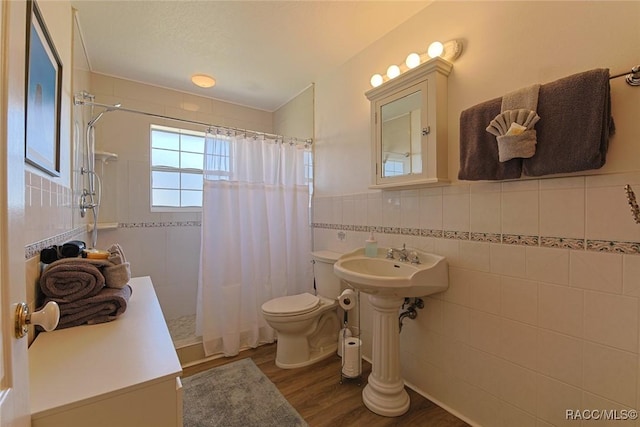 bathroom with tile walls, hardwood / wood-style floors, a shower with curtain, and toilet