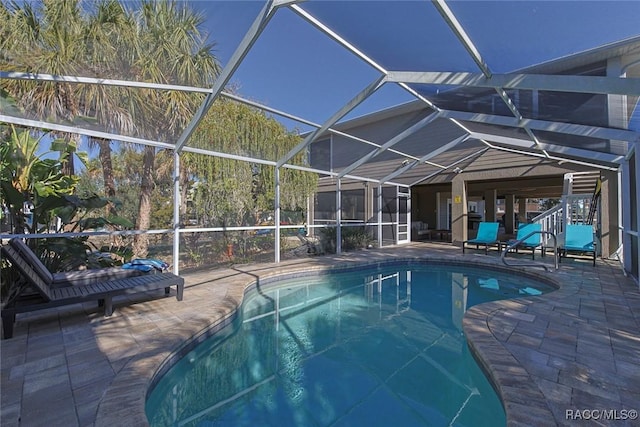 view of swimming pool featuring a patio area and glass enclosure