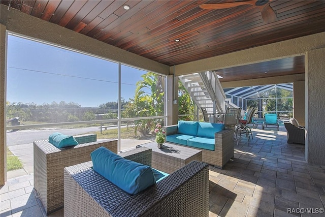 view of patio featuring an outdoor hangout area, ceiling fan, and glass enclosure