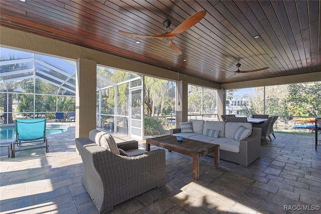 sunroom featuring wood ceiling and ceiling fan