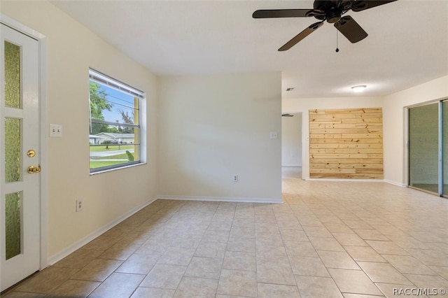 spare room with ceiling fan and light tile patterned floors