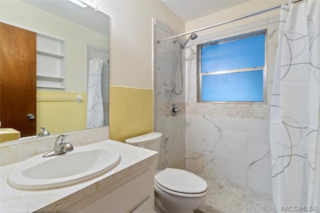 bathroom with a shower with curtain, vanity, toilet, and tile walls