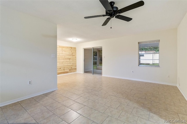 tiled spare room featuring ceiling fan