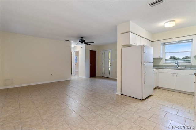 kitchen featuring white cabinets, sink, ceiling fan, a textured ceiling, and white fridge