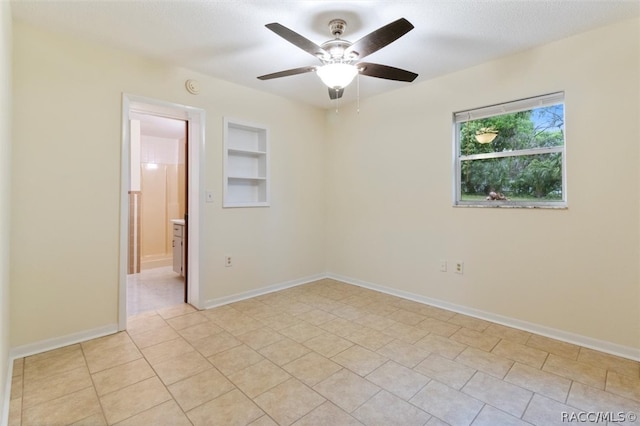 tiled spare room featuring a textured ceiling, built in features, and ceiling fan