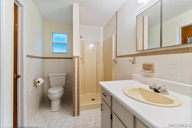 bathroom featuring toilet, a shower, tile walls, and vanity