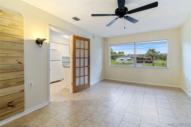 empty room featuring ceiling fan and light tile patterned flooring