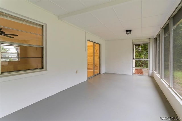 unfurnished sunroom featuring ceiling fan