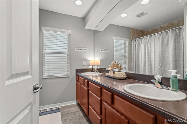 bathroom featuring double vanity, baseboards, visible vents, and a sink