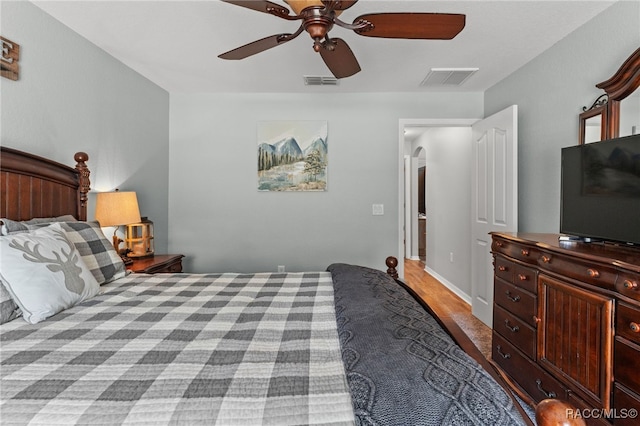 bedroom featuring arched walkways, visible vents, and ceiling fan