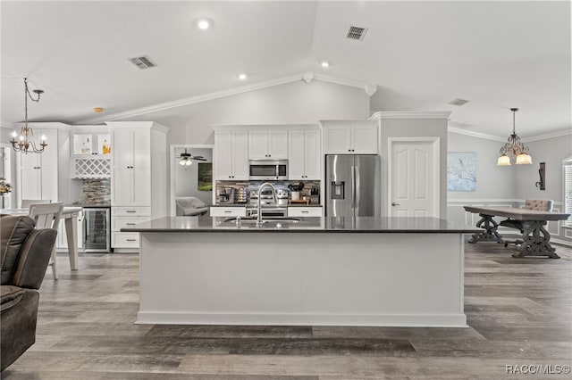 kitchen with dark countertops, visible vents, appliances with stainless steel finishes, and a sink