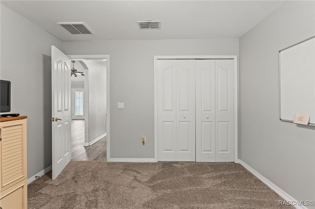 unfurnished bedroom featuring carpet floors, a closet, visible vents, and baseboards