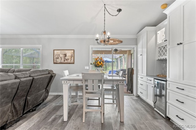 dining room with ornamental molding, wine cooler, dark wood-style flooring, and plenty of natural light