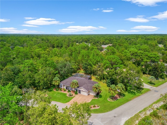 bird's eye view with a wooded view