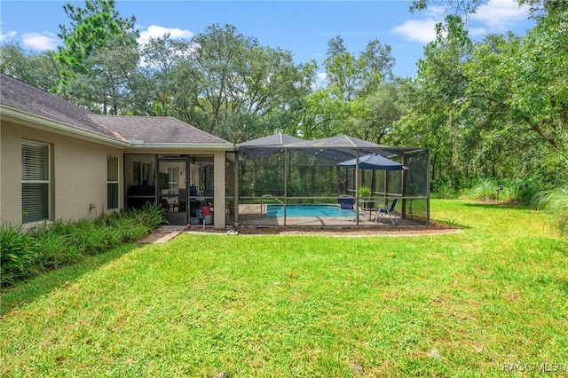 view of yard featuring glass enclosure, a patio area, and an outdoor pool