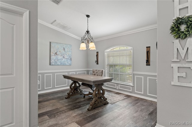 dining space featuring wood finished floors, wainscoting, crown molding, and an inviting chandelier