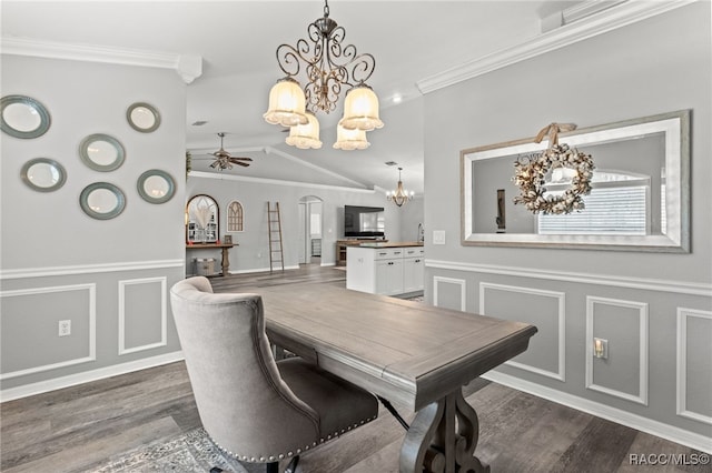 dining room featuring arched walkways, ornamental molding, wood finished floors, and a decorative wall