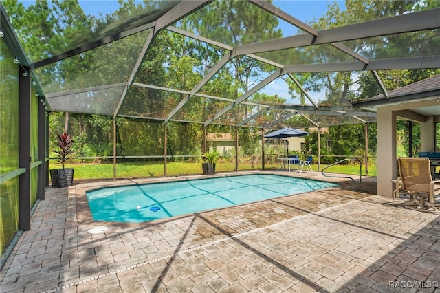 pool with glass enclosure and a patio area