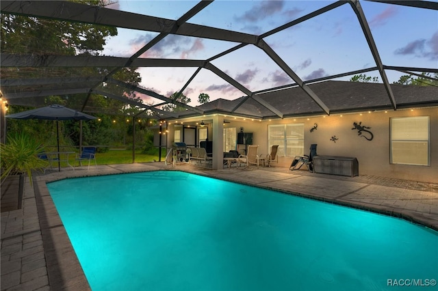 pool with glass enclosure and a patio area