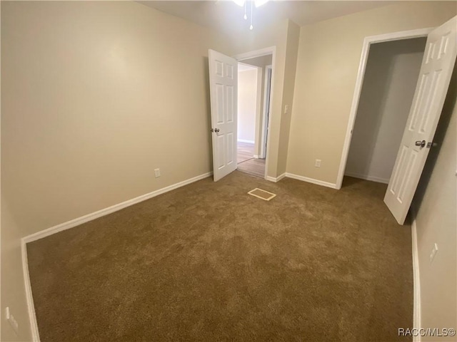 unfurnished bedroom with dark colored carpet