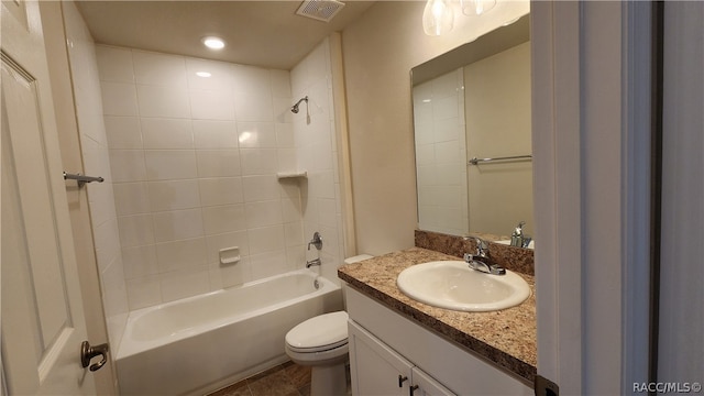 full bathroom featuring tiled shower / bath combo, toilet, and vanity