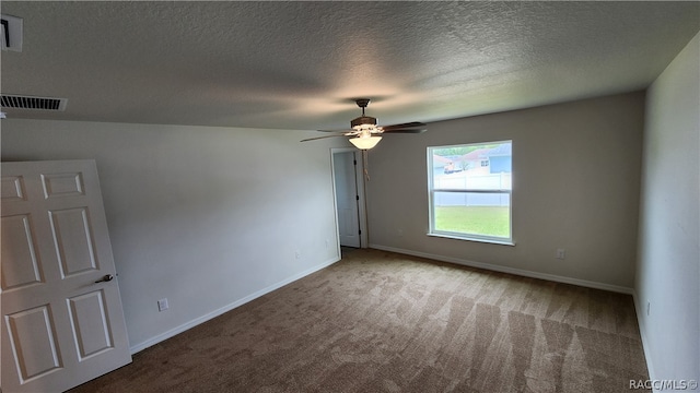 empty room with carpet flooring, a textured ceiling, and ceiling fan