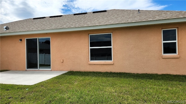 rear view of house featuring a yard and a patio area