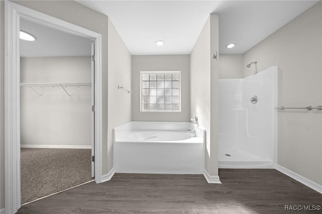 bathroom with shower with separate bathtub and hardwood / wood-style flooring