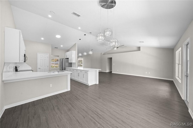 kitchen featuring dark hardwood / wood-style flooring, white cabinetry, kitchen peninsula, and vaulted ceiling