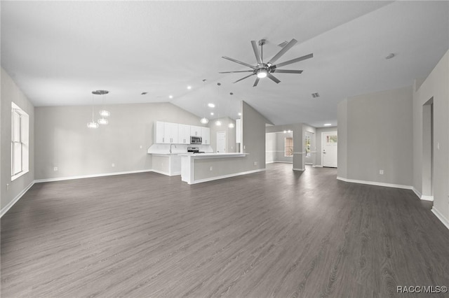 unfurnished living room with ceiling fan with notable chandelier, dark hardwood / wood-style floors, vaulted ceiling, and sink