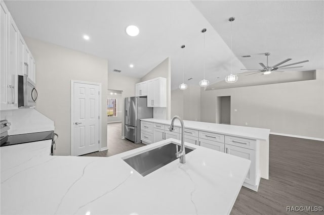 kitchen with light stone countertops, sink, pendant lighting, white cabinets, and appliances with stainless steel finishes