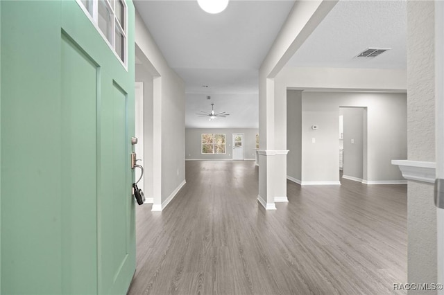 foyer featuring wood-type flooring, decorative columns, and ceiling fan