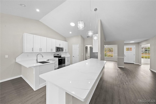 kitchen featuring kitchen peninsula, sink, appliances with stainless steel finishes, decorative light fixtures, and white cabinetry