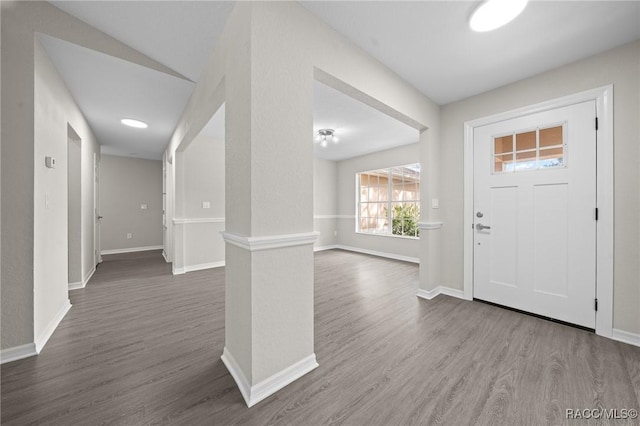 entryway featuring wood-type flooring and decorative columns