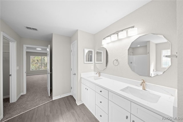 bathroom featuring vanity, wood-type flooring, and walk in shower