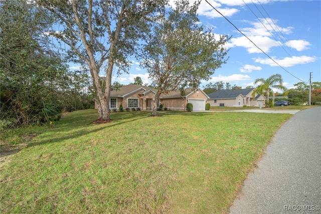 single story home featuring a front yard and a garage