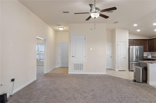 unfurnished living room with lofted ceiling, light colored carpet, and ceiling fan